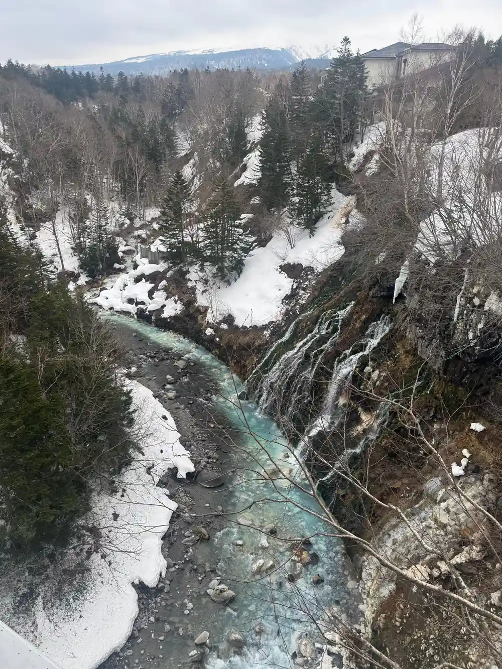 Aerial view of snow-covered landscape with turquoise river