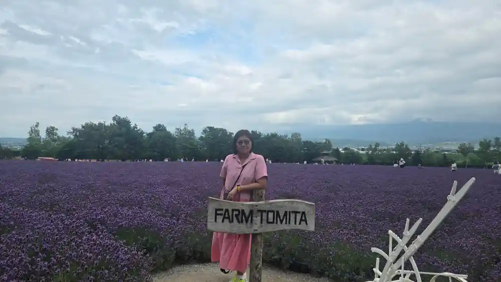 Woman at lavender farm sign posing